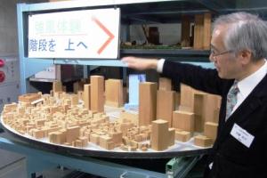 東京駅周辺の縮尺模型を前に、風洞実験について解説する加藤信介教授