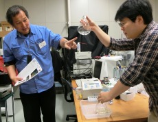 ホタルの酵素を使った生物発光反応実験について説明する秋山教授