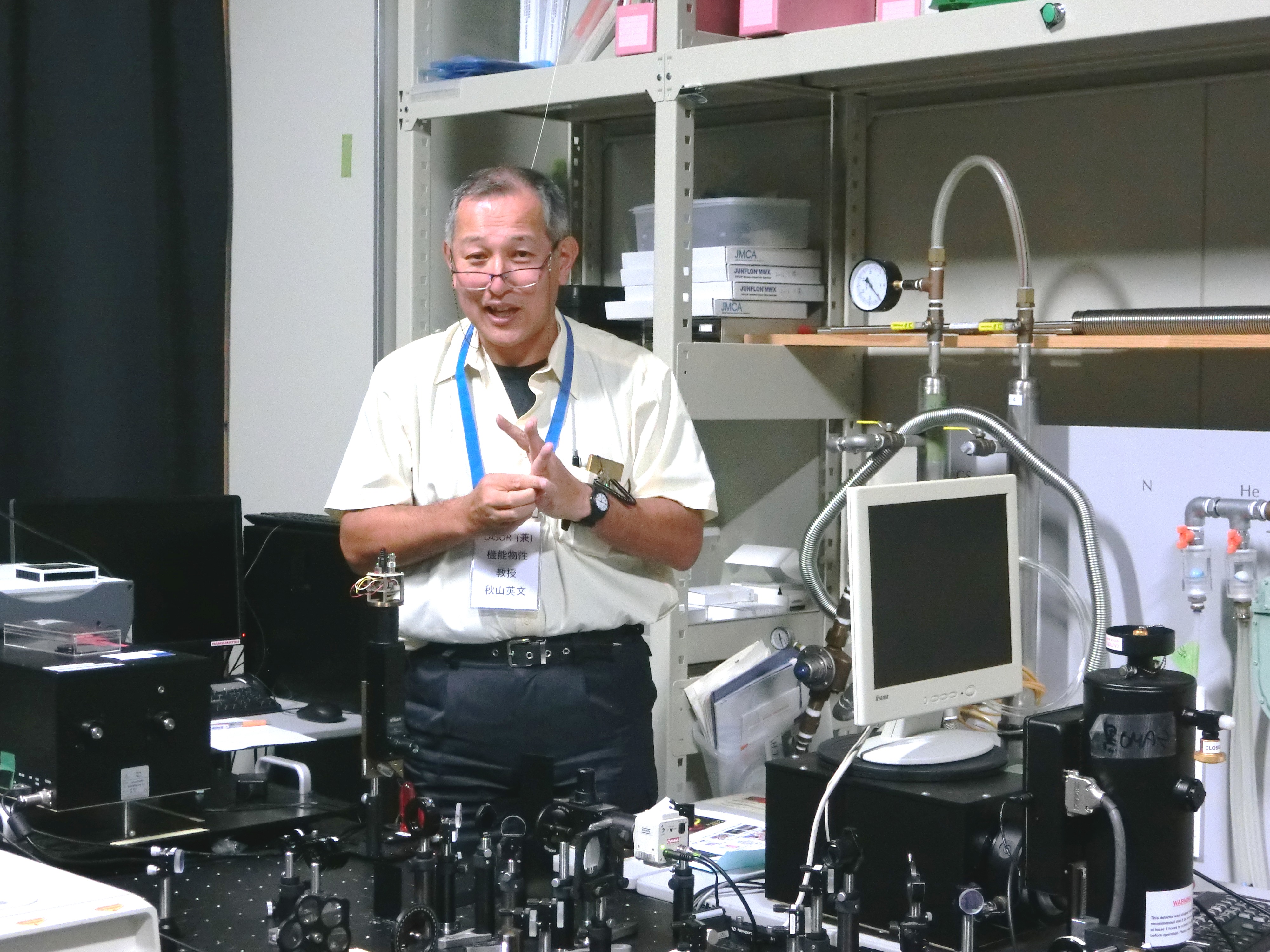 半導体レーザーの実験装置について解説する秋山教授