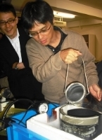 クロロフィル(葉緑素)の発光(赤色)のデモンストレーションを行う小島教授